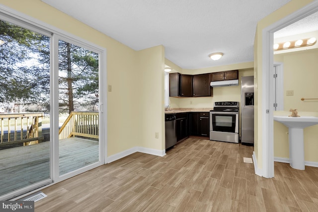 kitchen featuring light wood-type flooring, dark brown cabinets, a textured ceiling, stainless steel appliances, and sink