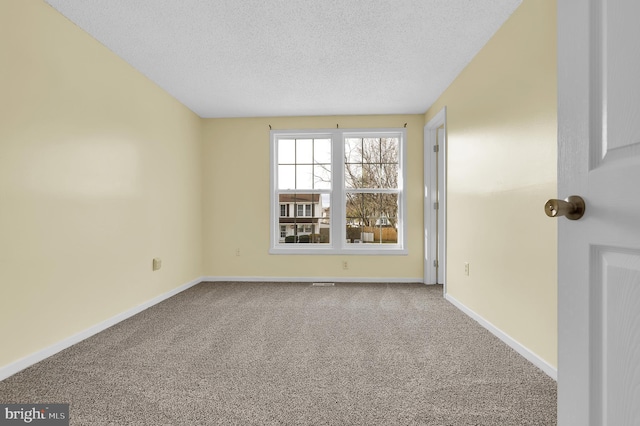 carpeted empty room featuring a textured ceiling