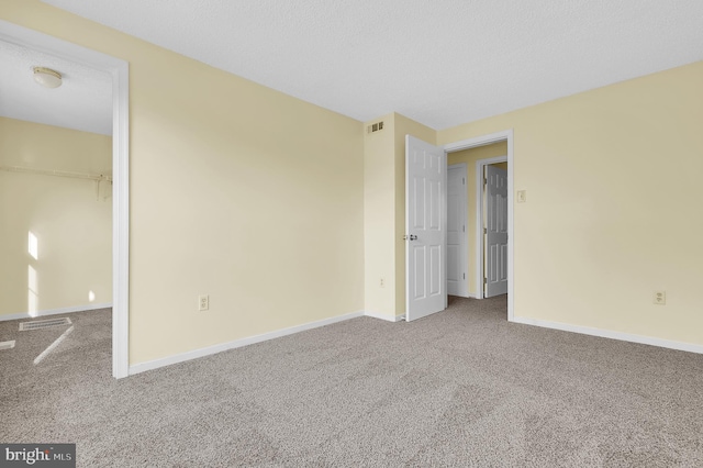 unfurnished room featuring carpet flooring and a textured ceiling