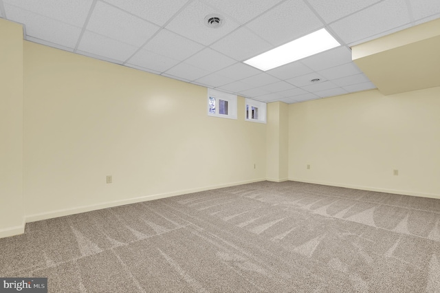 basement featuring carpet flooring and a paneled ceiling