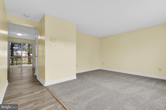 unfurnished room with light colored carpet and a textured ceiling