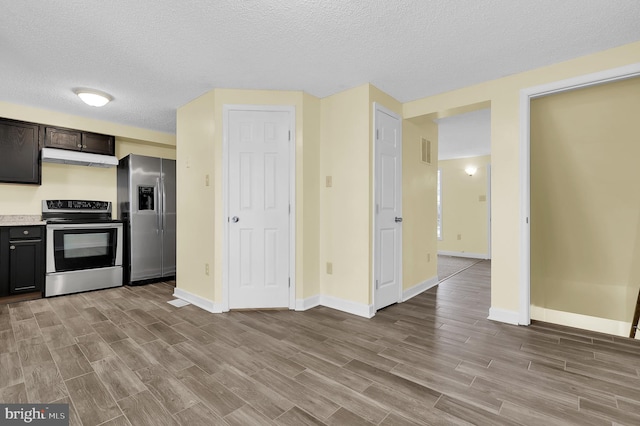 kitchen with light hardwood / wood-style floors, dark brown cabinetry, a textured ceiling, and appliances with stainless steel finishes