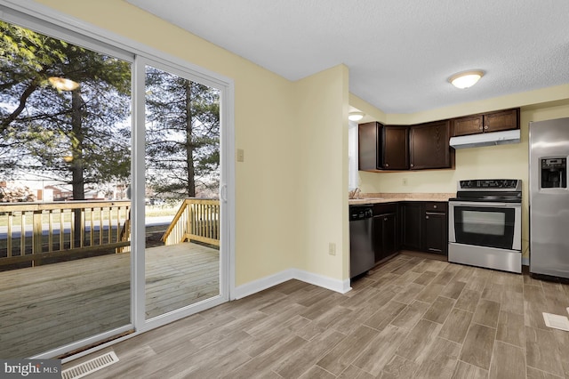 kitchen featuring dark brown cabinets, a textured ceiling, stainless steel appliances, and light hardwood / wood-style floors