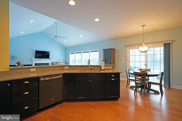 kitchen featuring dishwasher, light stone countertops, a healthy amount of sunlight, and sink