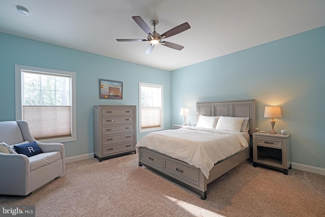 bedroom with multiple windows, light colored carpet, and ceiling fan