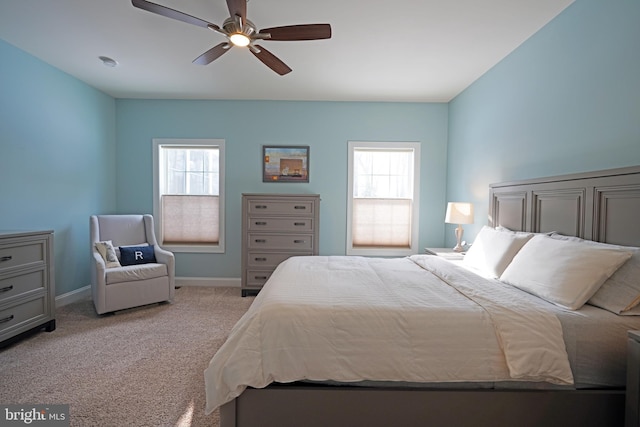 bedroom featuring multiple windows, ceiling fan, and light colored carpet