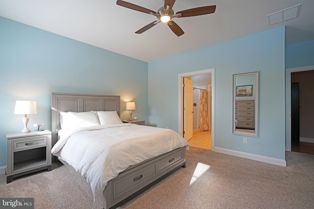 bedroom featuring ensuite bathroom, ceiling fan, and light carpet