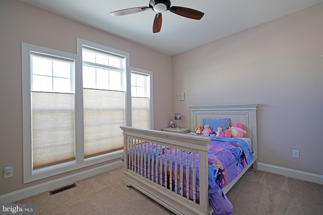 carpeted bedroom with multiple windows and ceiling fan