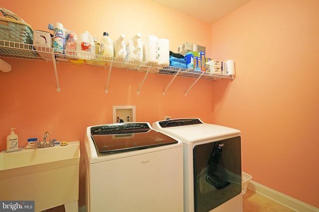 clothes washing area featuring washer and dryer and sink