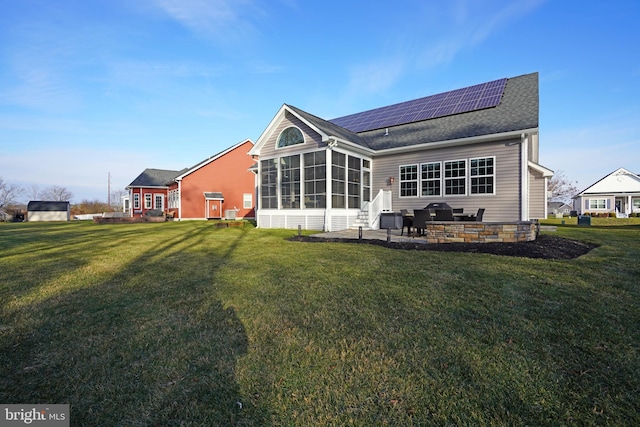 rear view of house with solar panels, a yard, and a sunroom