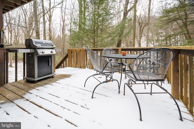 snow covered deck featuring a grill