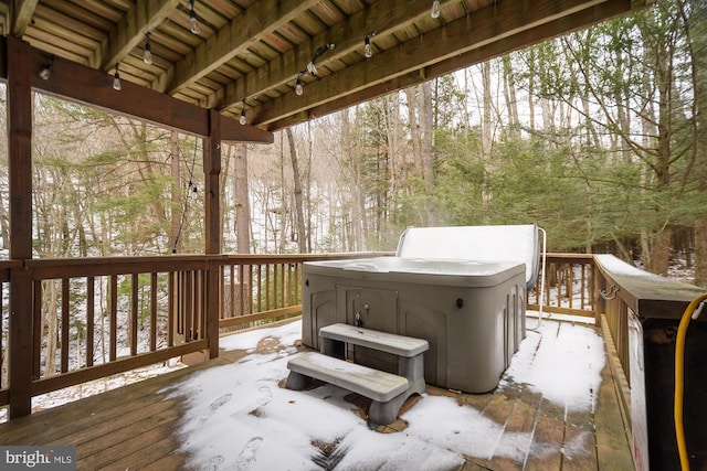 snow covered deck with a hot tub