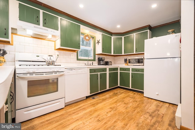 kitchen with decorative backsplash, white appliances, light hardwood / wood-style floors, and green cabinets