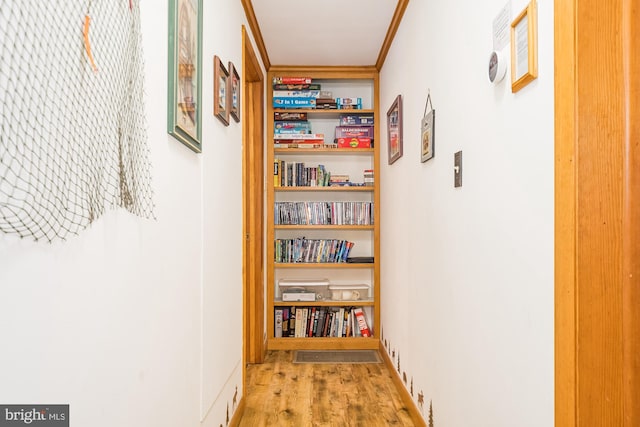 hallway featuring light hardwood / wood-style floors and crown molding