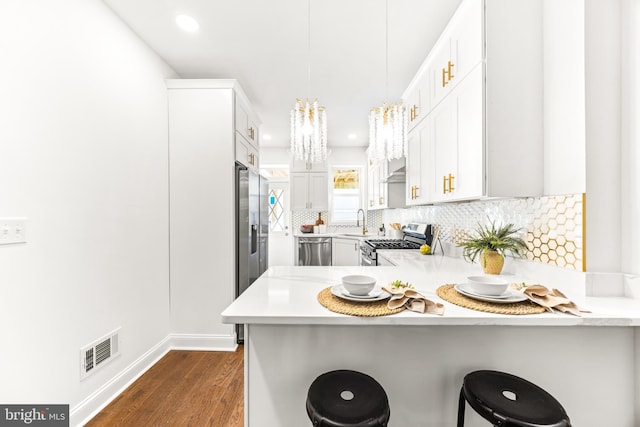 kitchen featuring kitchen peninsula, stainless steel appliances, and a breakfast bar area