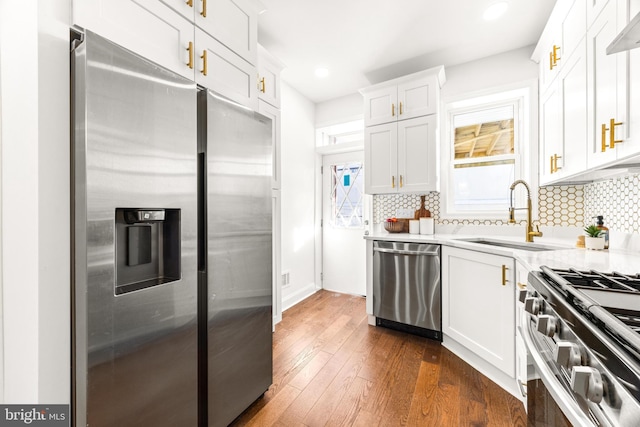 kitchen with sink, decorative backsplash, dark hardwood / wood-style floors, white cabinetry, and stainless steel appliances