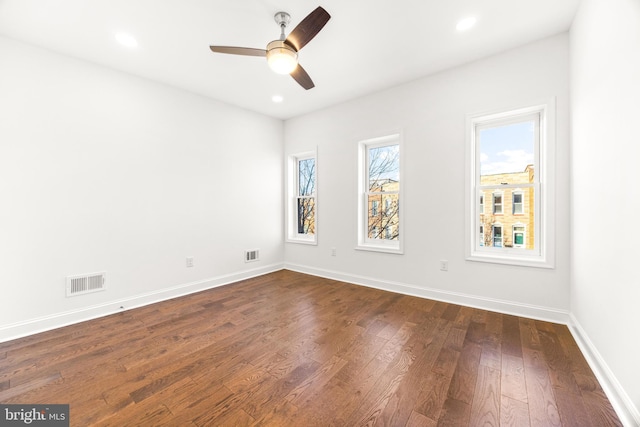 unfurnished room with ceiling fan and dark wood-type flooring