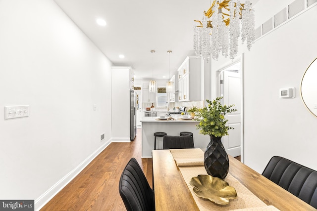 dining space with a chandelier and hardwood / wood-style floors