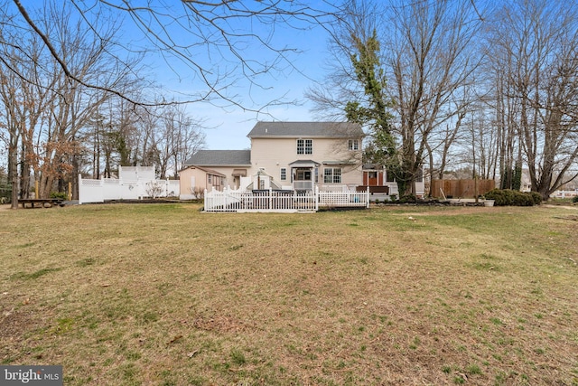 back of house featuring a deck and a yard