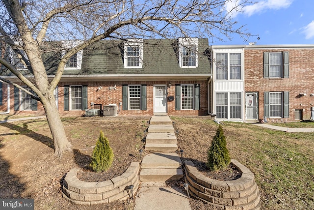 view of front of property with central AC unit and a front yard