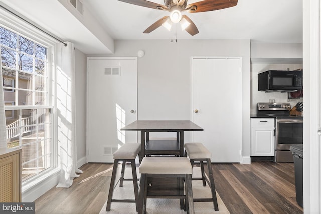 dining room with ceiling fan and dark hardwood / wood-style flooring