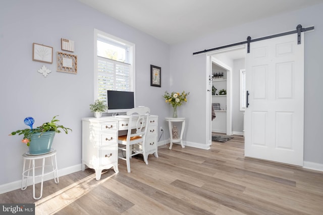 office space featuring a barn door and light hardwood / wood-style flooring