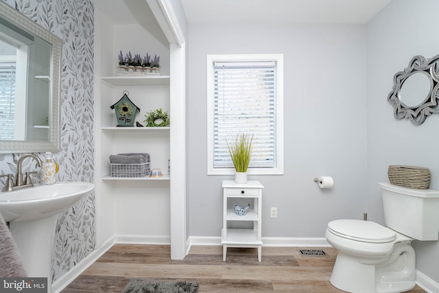 bathroom with toilet and wood-type flooring