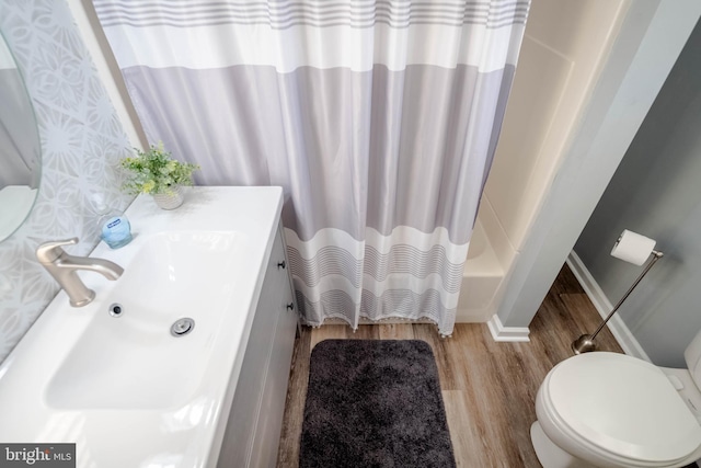 full bathroom with toilet, wood-type flooring, sink, and shower / tub combo