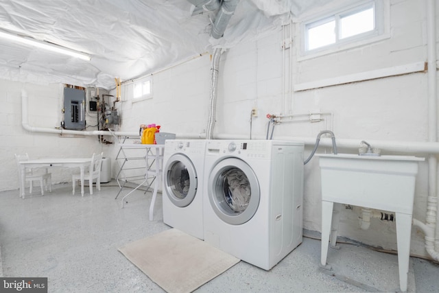 washroom with a healthy amount of sunlight, separate washer and dryer, and electric panel