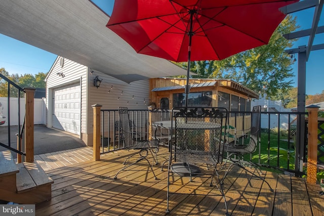 wooden deck featuring an outdoor structure and a garage