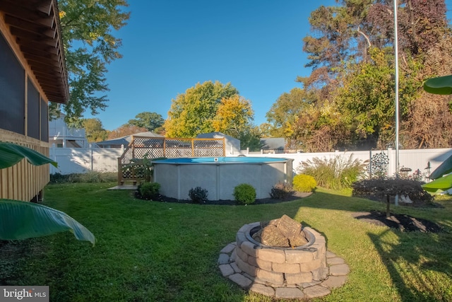 view of yard with a fenced in pool and an outdoor fire pit