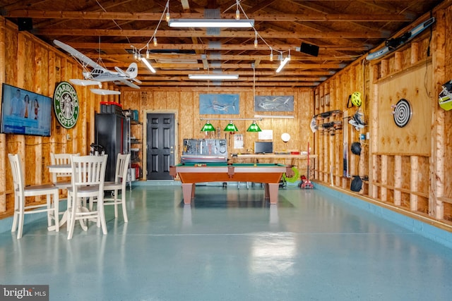 recreation room with wooden walls, pool table, and concrete floors