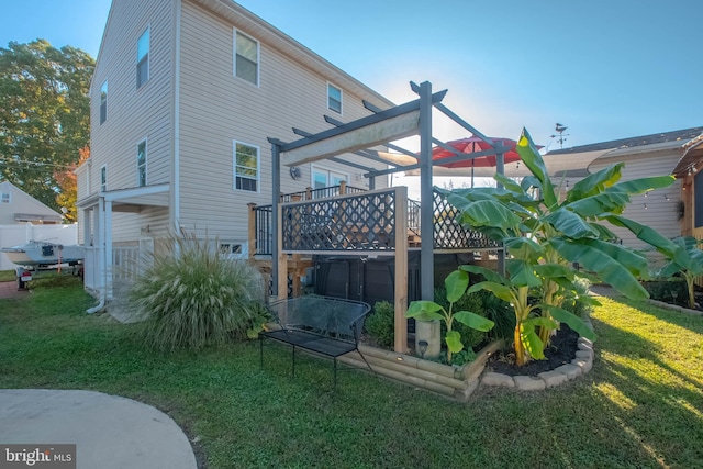 rear view of house featuring a lawn and a wooden deck