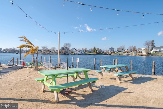 surrounding community with a boat dock and a water view