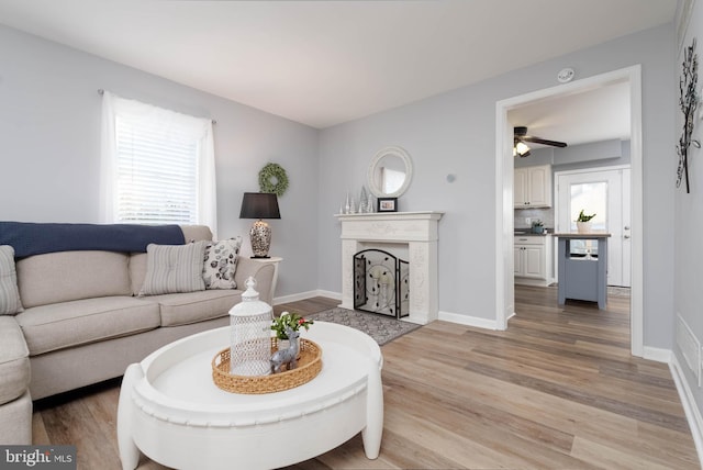 living room with ceiling fan, light hardwood / wood-style flooring, and a healthy amount of sunlight