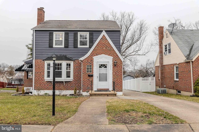 view of front facade with a front yard and central AC