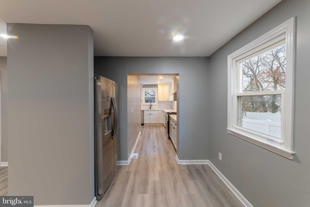 hall featuring light hardwood / wood-style flooring and sink