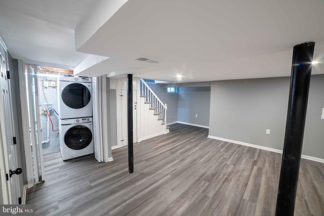 basement with wood-type flooring and stacked washer and clothes dryer