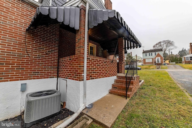 view of side of home with a lawn and cooling unit