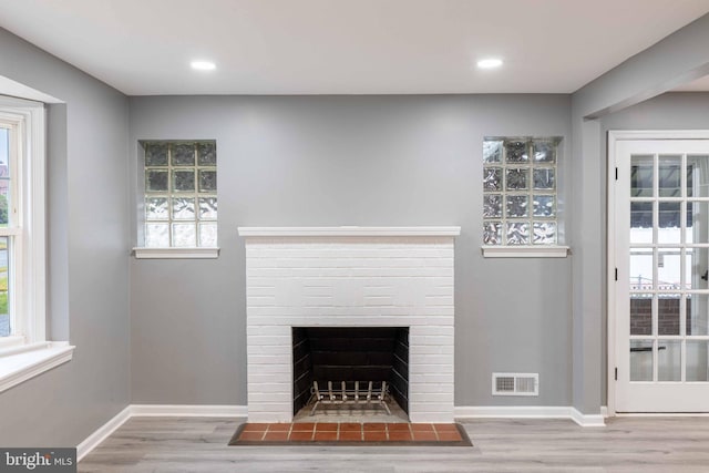 room details featuring wood-type flooring and a brick fireplace