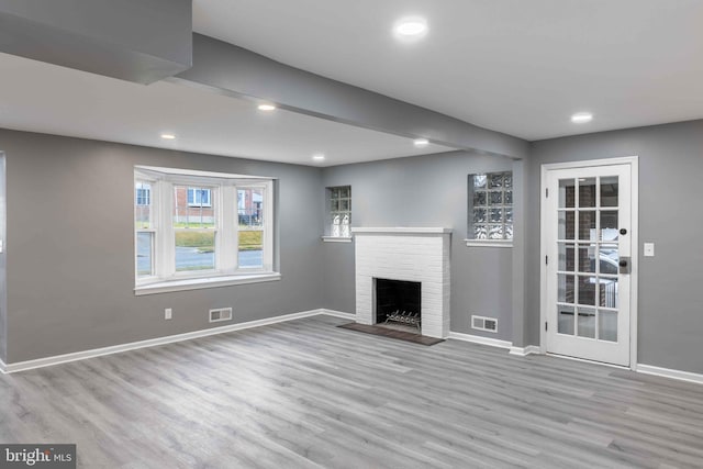 unfurnished living room with a fireplace and light hardwood / wood-style floors