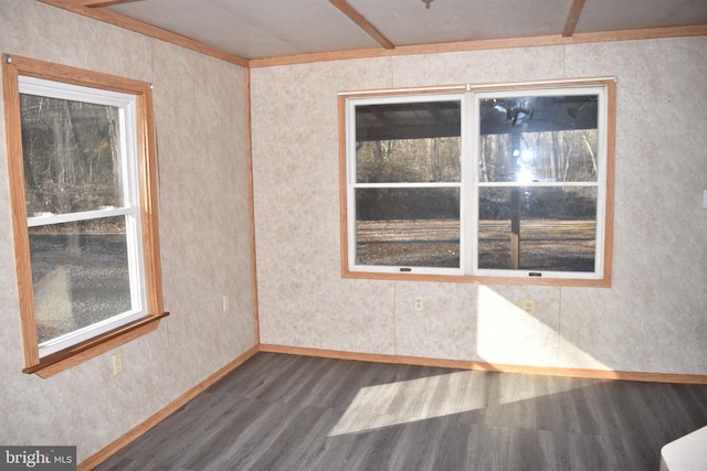 unfurnished room with beamed ceiling and dark wood-type flooring