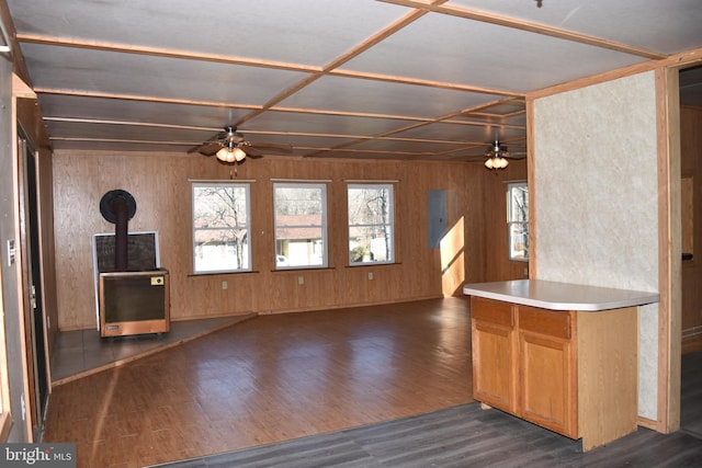 kitchen featuring a wood stove, wood walls, dark hardwood / wood-style flooring, and ceiling fan