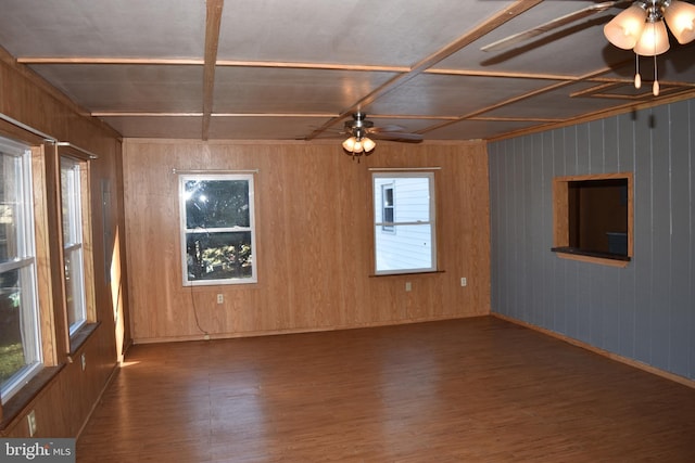 spare room featuring dark hardwood / wood-style floors and wooden walls