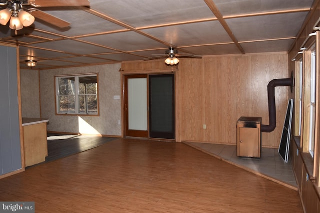 spare room with ceiling fan, wood walls, wood-type flooring, and coffered ceiling