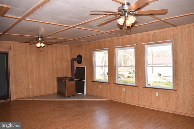 unfurnished living room featuring wooden walls and plenty of natural light