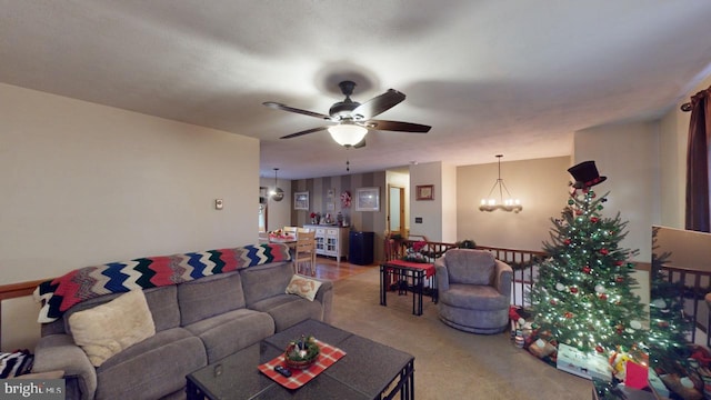 carpeted living room featuring ceiling fan with notable chandelier