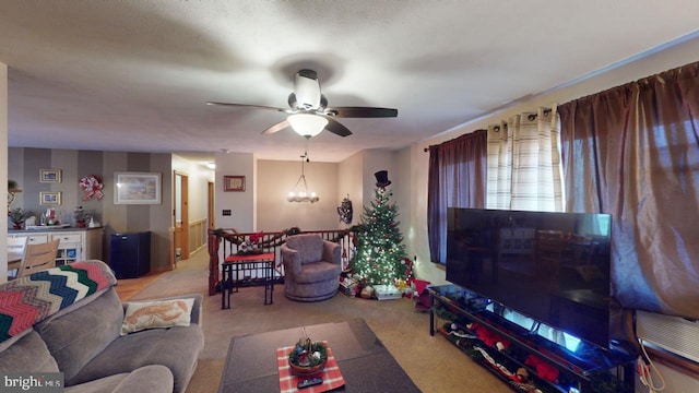 carpeted living room with ceiling fan with notable chandelier