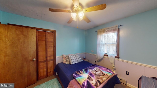 bedroom with carpet flooring, a closet, a baseboard radiator, and ceiling fan