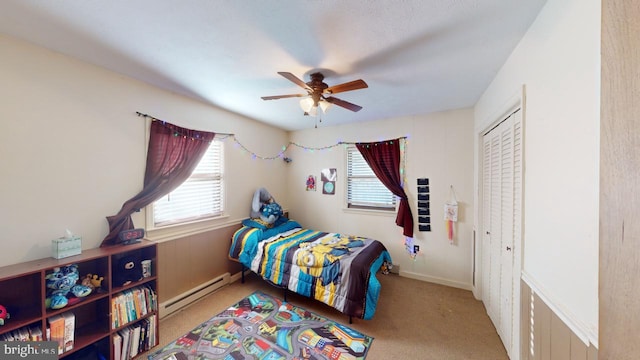 bedroom featuring carpet floors, a closet, baseboard heating, and ceiling fan